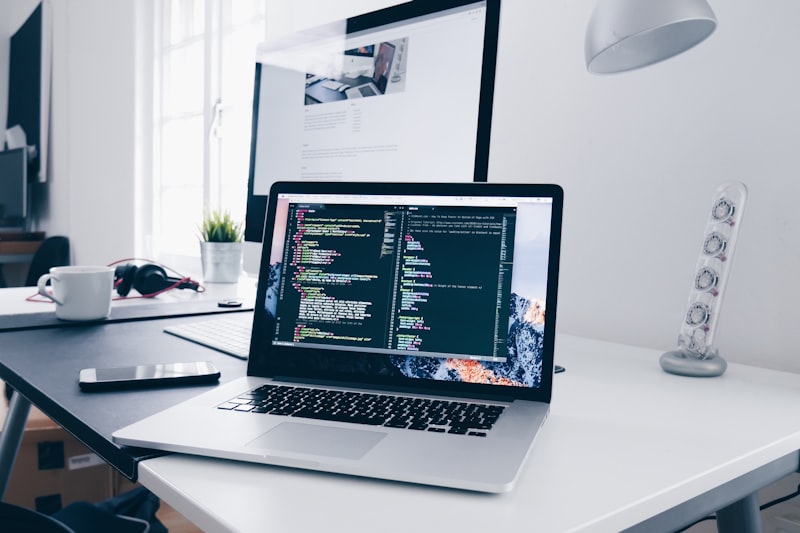 Developer writing custom software on dual monitors in a modern office