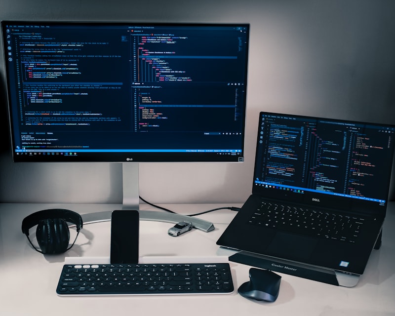 Developer reviewing custom business operations software on office monitors