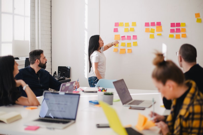Business consultant reviewing digital strategy roadmap with client team at whiteboard